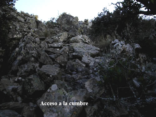 Para acceder a la cumbre hay que abandonar el camino y tomar una pequeña senda que sale a nuestra derecha justo cuando la vía principal hace una curva a la izquierda y comienza descender. La senda, poco definida, nos lleva hacia las rocas de la cumbre. 